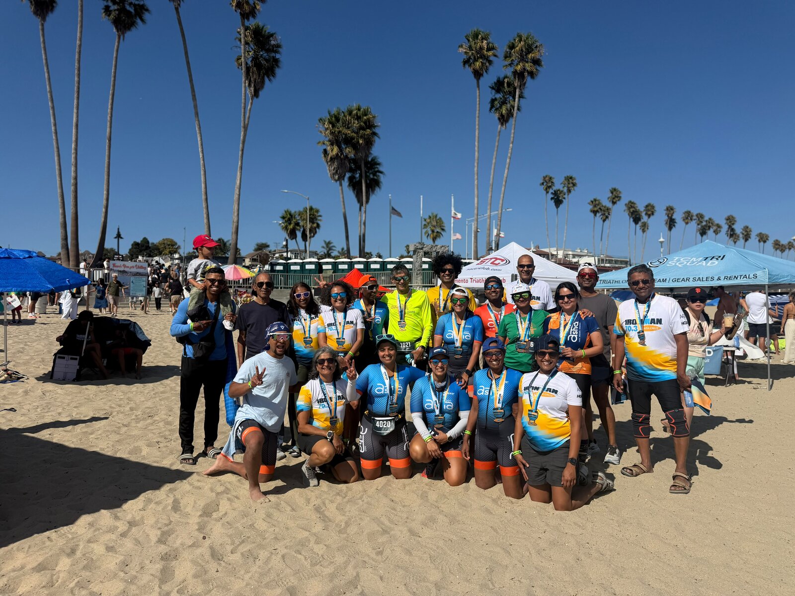 Team Asha celebrating with medals on Santa Cruz beach after the race